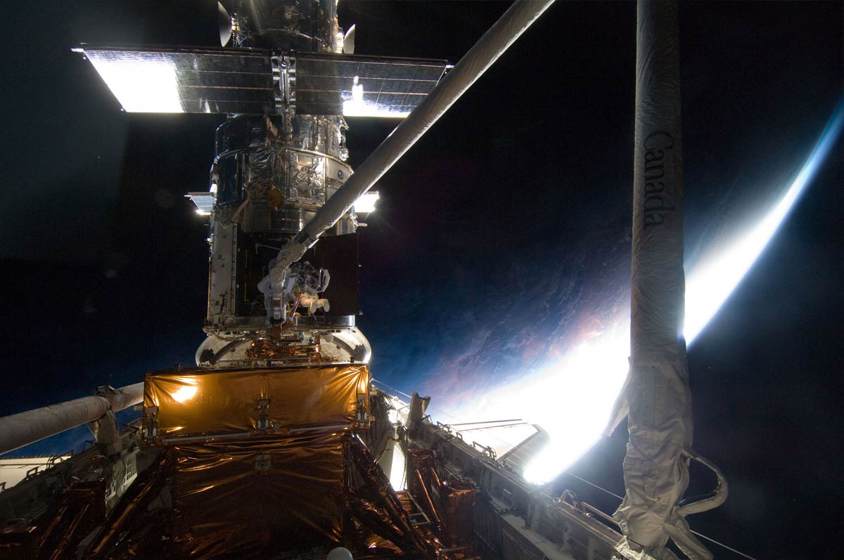Майкл Гуд на маніпуляторі Canadarm шатла Atlantis наближається до телескопа Hubble